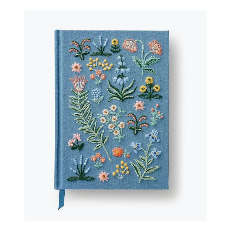 Image of a blue embroidered journal with a floral design featuring various flowers and leaves, on a white background